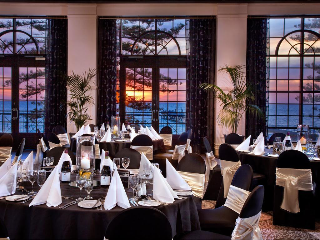 Stamford Grand Adelaide Hotel Glenelg Ngoại thất bức ảnh The photo shows an elegant dining setup inside a venue with large windows. The tables are adorned with black tablecloths and white napkins arranged in a stylish manner. Each table has glassware and other dining utensils placed neatly. In the backgrou